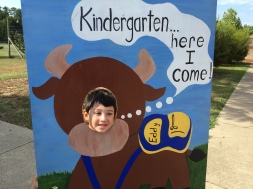 Kindergartener poses with DPS sign